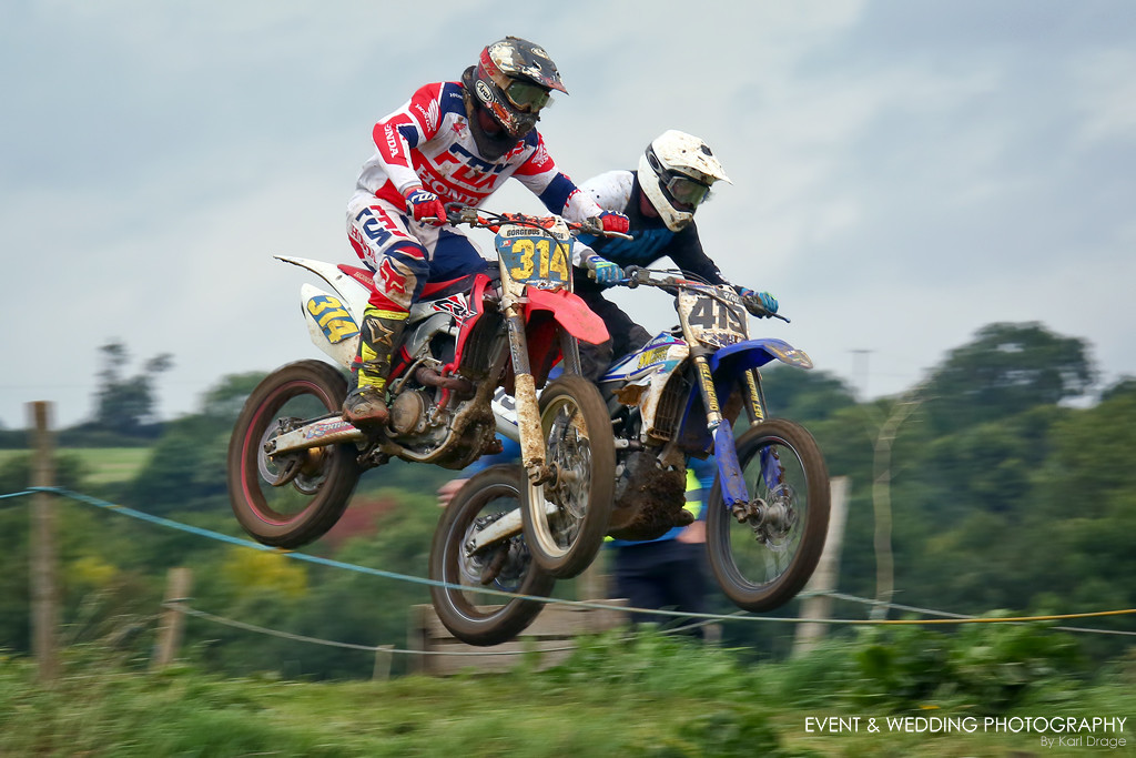 Two riders crest a jump at the motocross track at Woodford, Northants.