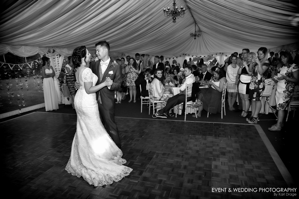 Black and white shot of a new husband and wife enjoying the first dance in the marquee at their Huntsmill Farm wedding