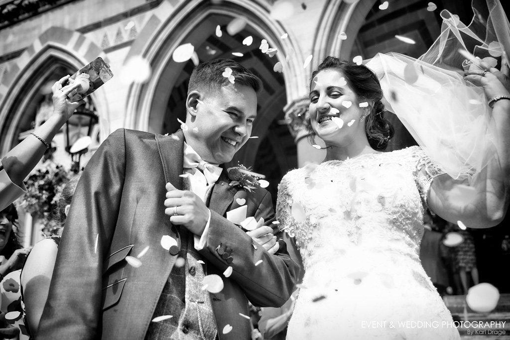 The bride and groom shield their eyes from confetti after their Northampton Guildhall wedding ceremony