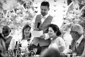A reassuring hug from the bride as the groom makes his wedding speech - by Brackley wedding photographer Karl Drage
