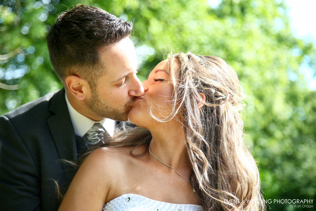 A tender kiss between bride and groom on their wedding day - by Raunds wedding photographer Karl Drage