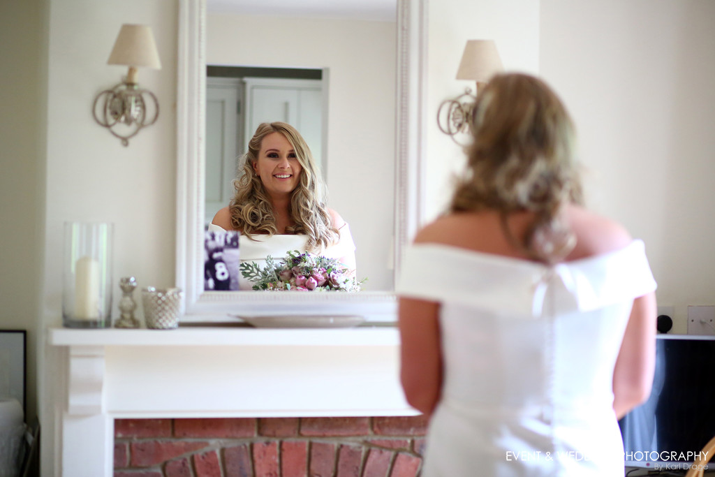 Image showing a bride checking out her appearance in a mirror before her Kelmarsh Hall wedding ceremony.