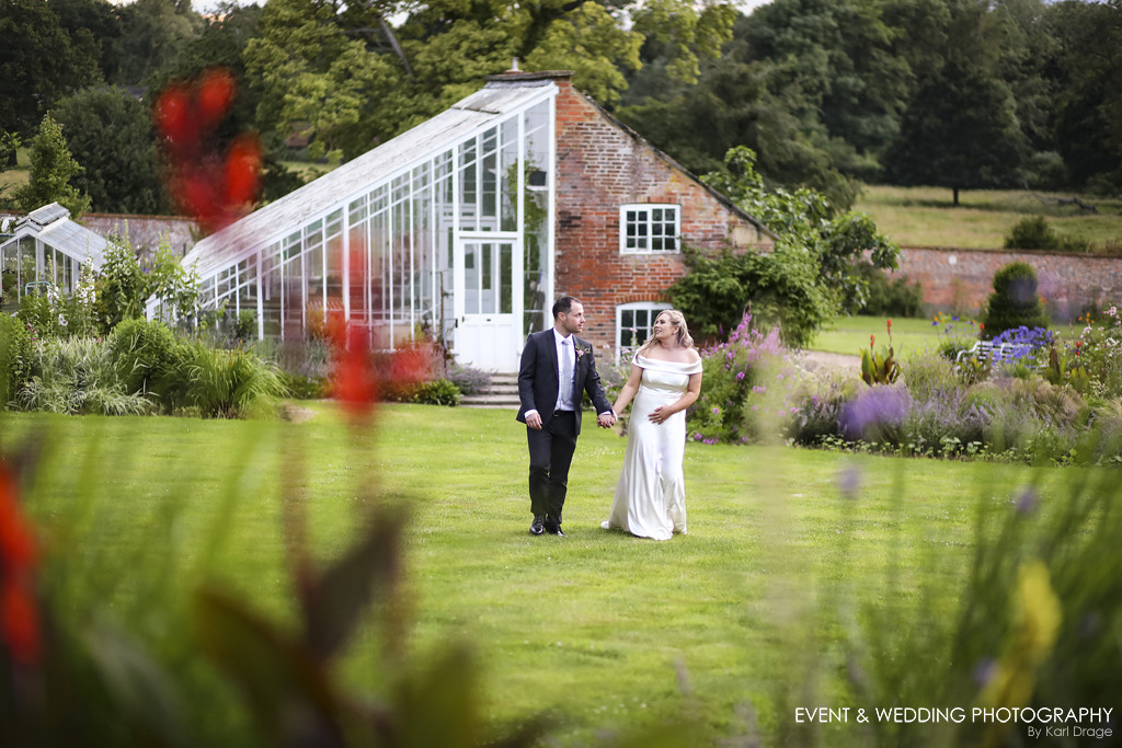 Bride and groom walking through the stunning gardens on their Kelmarsh Hall wedding day