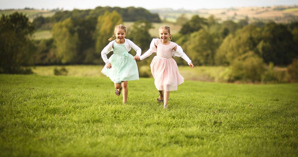 Image of two twin girls running through a field