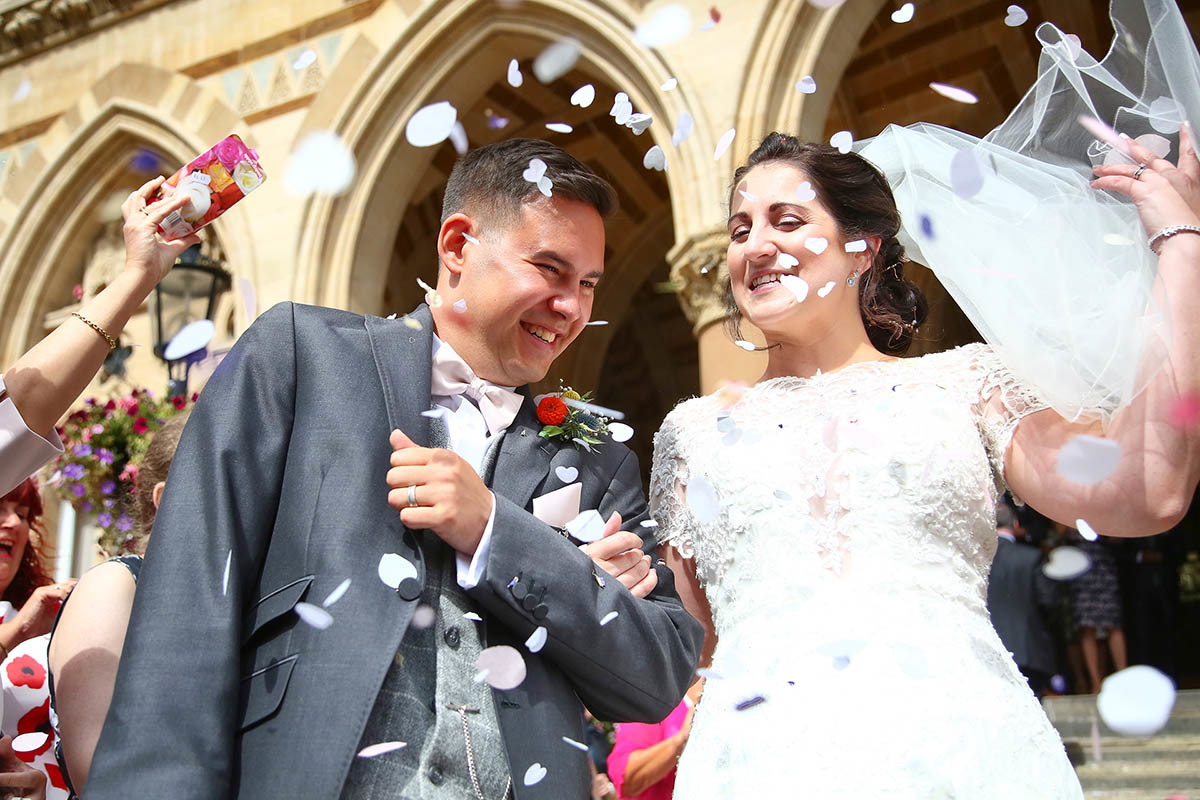 Bride and groom getting showered with confetti
