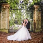 Bride and groom pictured in front of wrought iron gates