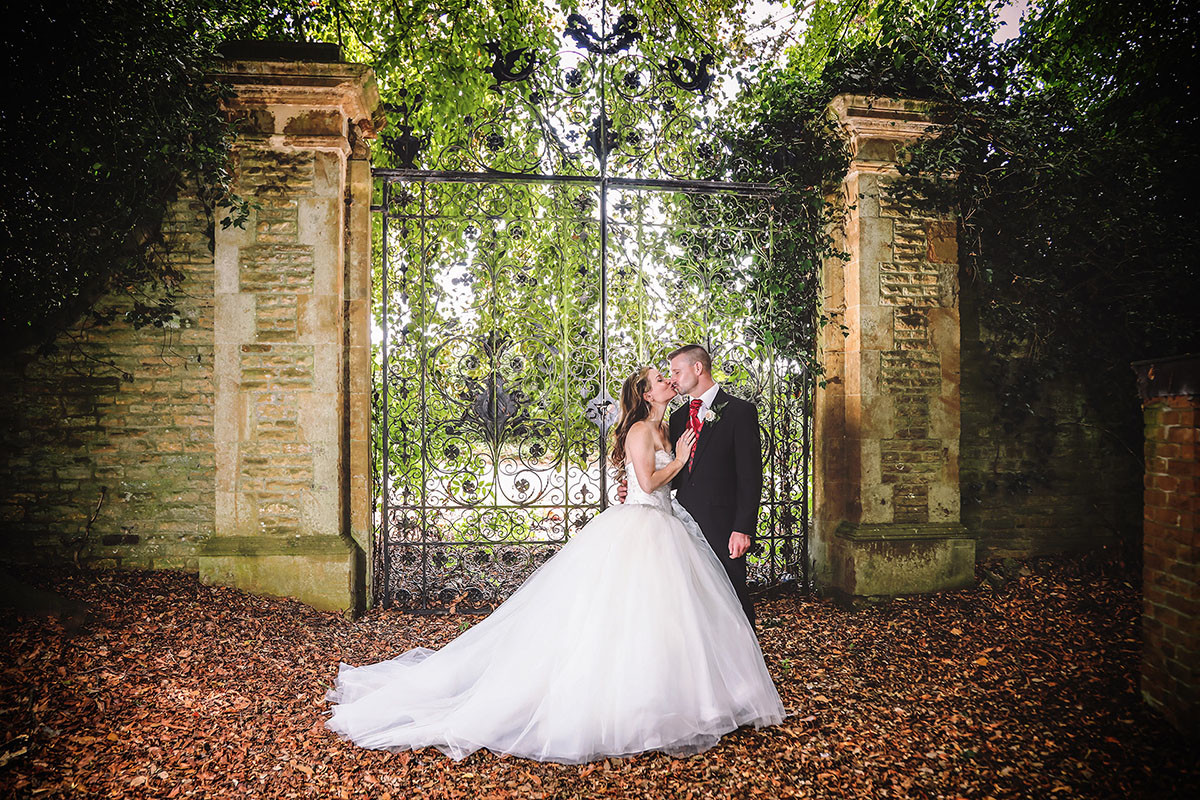 Bride and groom pictured in front of wrought iron gates