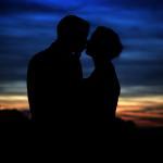 Bride and groom kissing after the sun has set