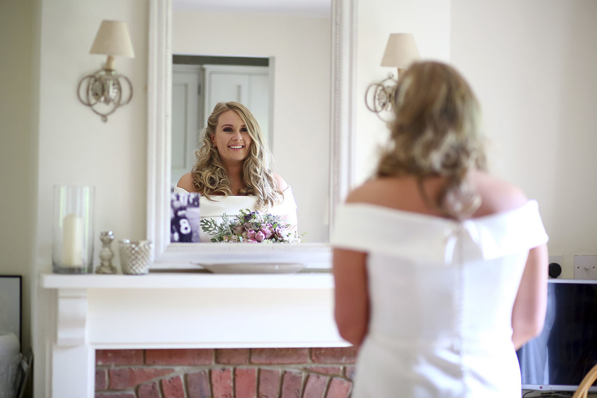 Bride reflected in a mirror before her wedding day.