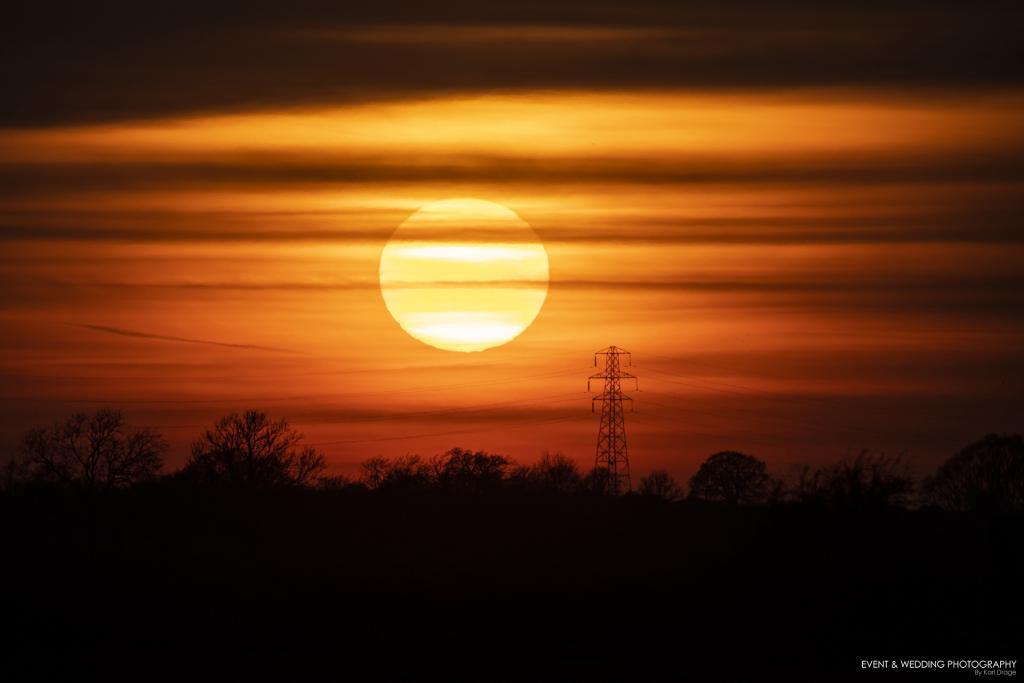 Image showing a setting sun close to an electricity pylon
