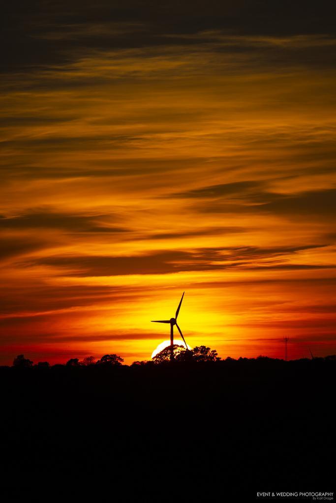Wind turbine during a stunning red-skied sunset