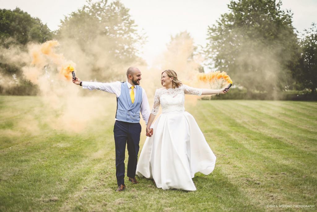 Bride and Groom carrying smoke bombs on their wedding day