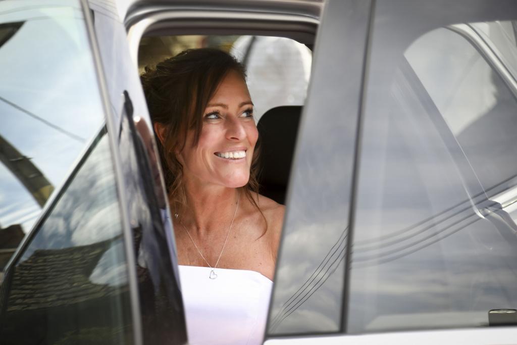 Bride sitting in her wedding car