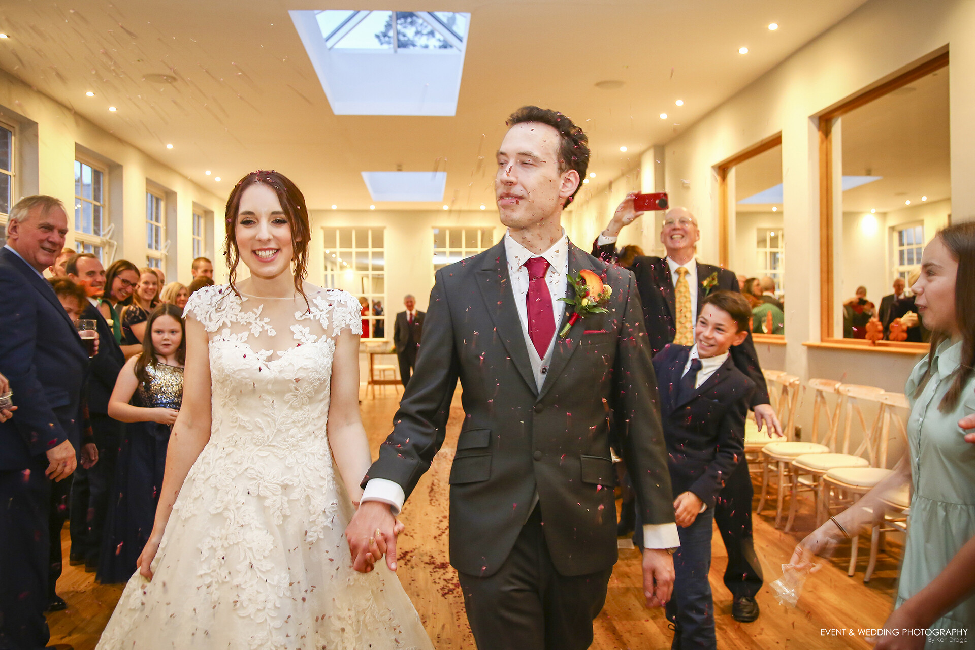 The Bride & Groom walk towards the camera at Bredenbury Court Barns as their guests throw confetti