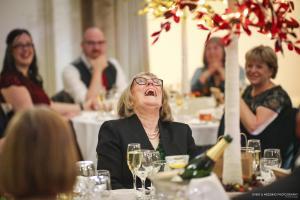 Guest at a wedding laughing at the speeches