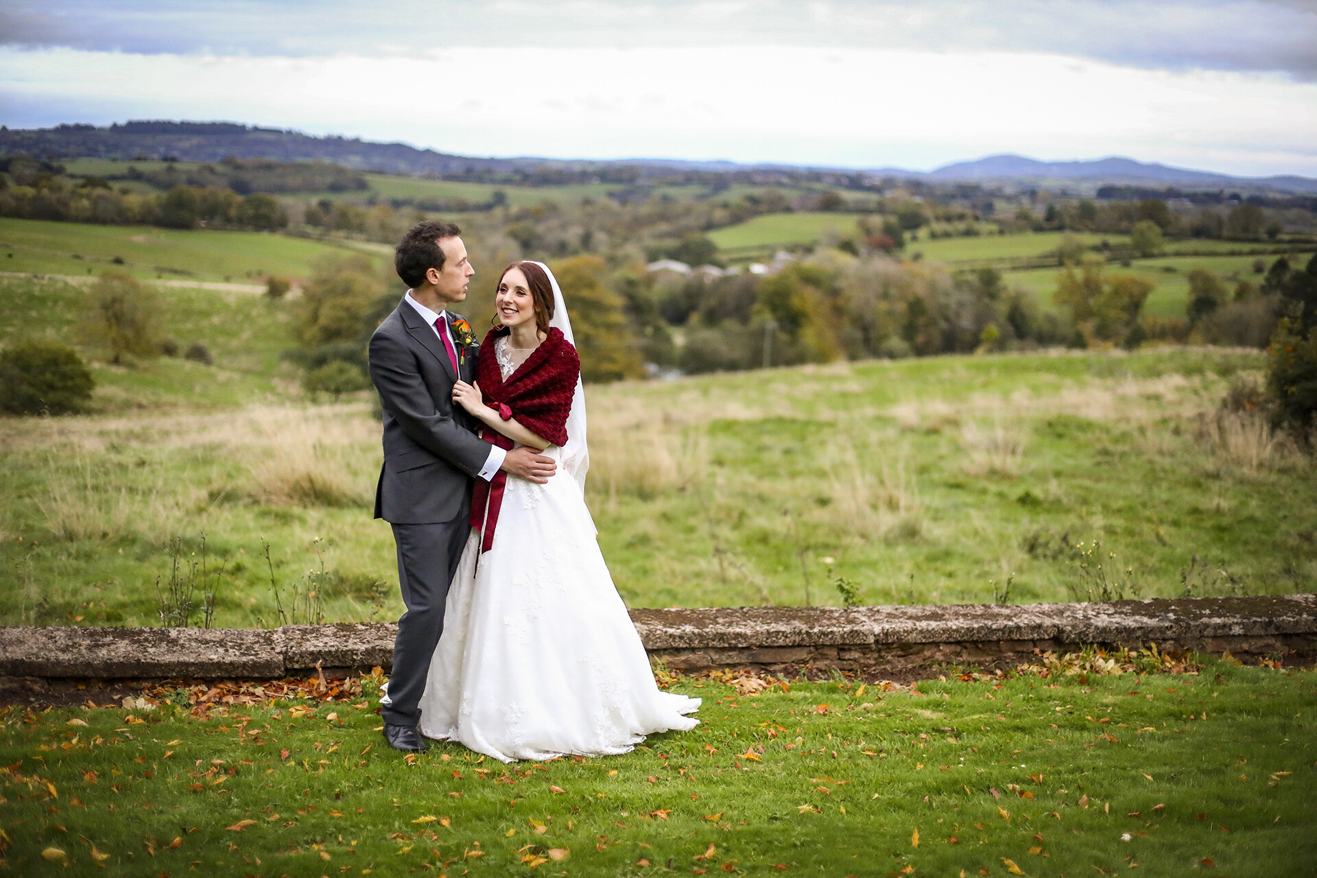The Bride & Groom embrace with stunning rolling hills of Herefordshire beyond