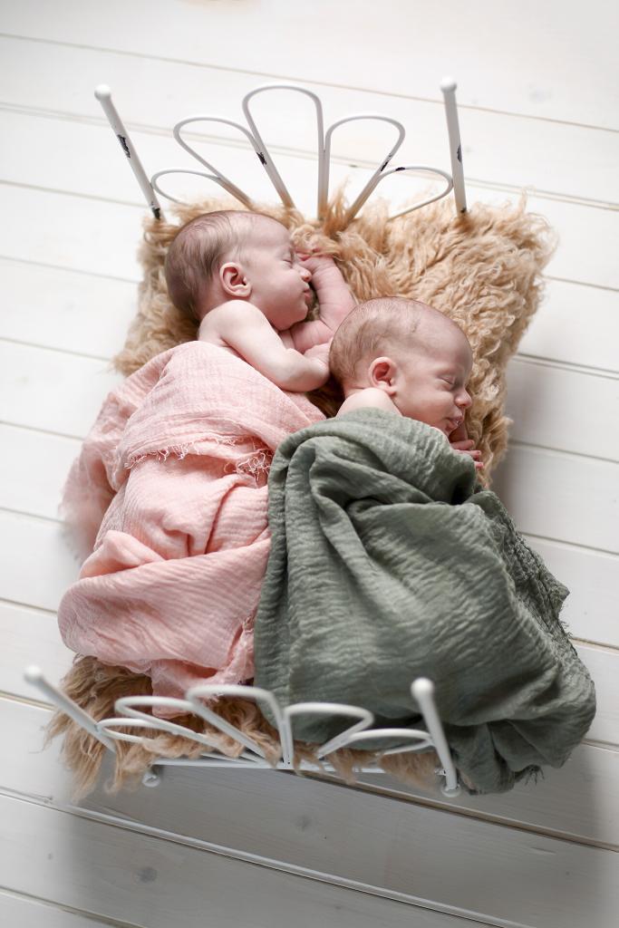Twins asleep on a large white vintage bed newborn photography prop