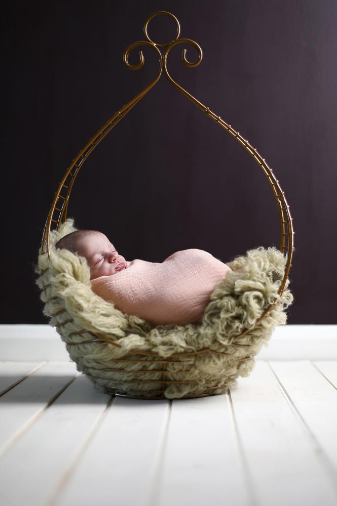 Ornate vintage bed newborn photography prop with baby girl asleep