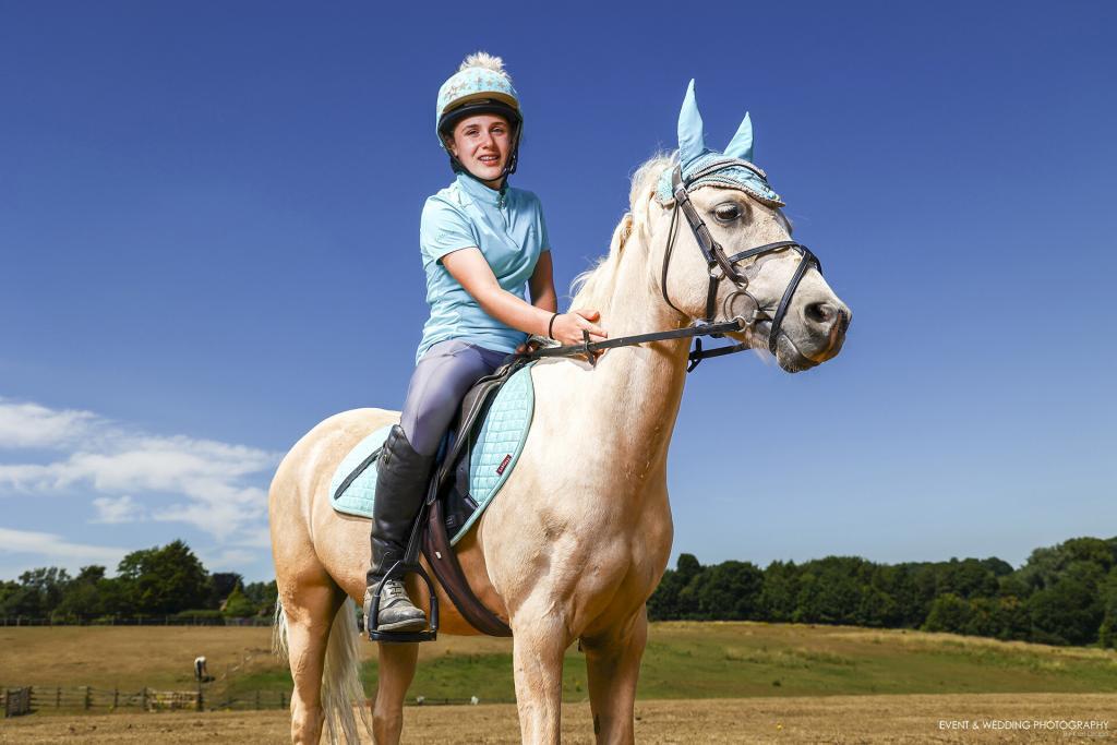 Girl sitting on her palomino pony wearing LeMieux's Azure Colour Collection