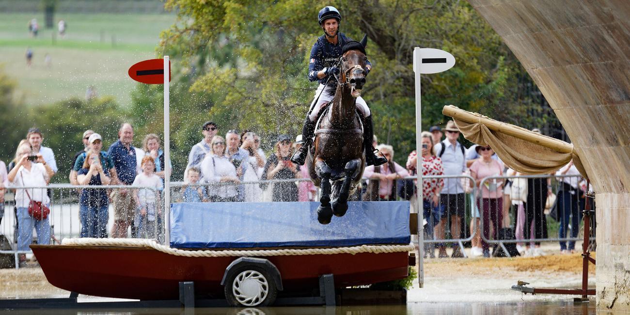 Arthur Duffort and Toronto D'Aurois sail over the boat at Lion Bridge during their run in the Cross Country at the 2022 Land Rover Burghley Horse Trials