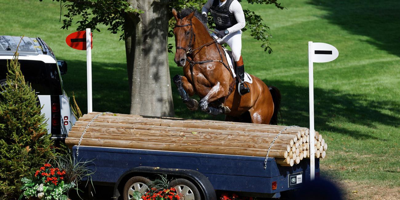 Harry Mutch & HD Bronze lift off at the log trailer at The Trout Hatchery at the Burghley Horse Trials 2022