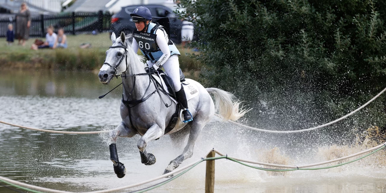 Kitty King & Vendredi Biats splash through the water at the Boodles Raindance during Burghley Horse Trials 2022.