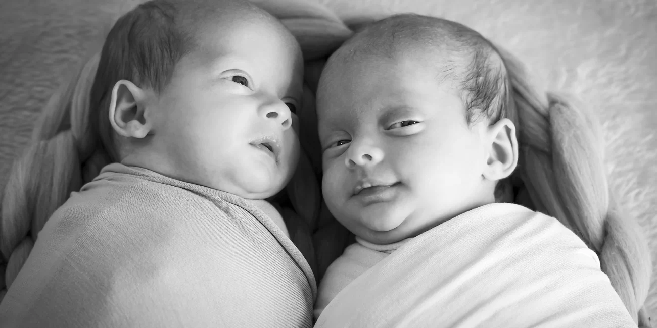 Newborn baby twins in a woven woollen basket