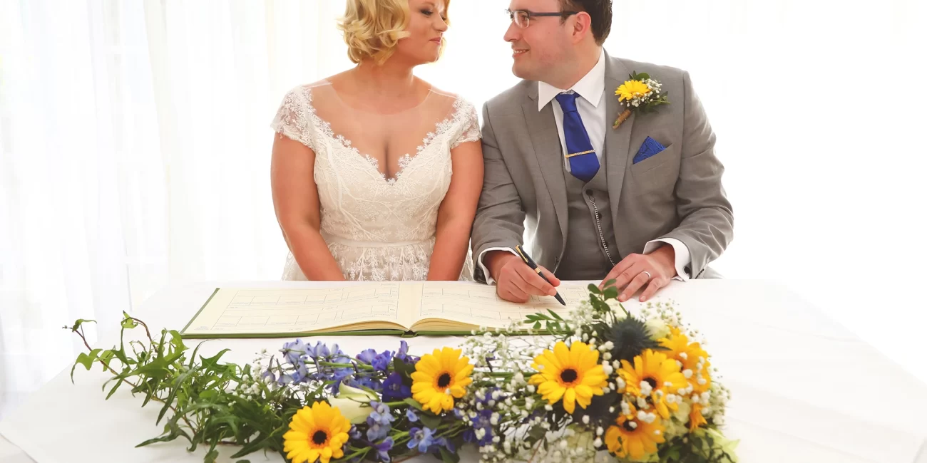 The Bride and Groom exchange a glance as they signed the Wedding Register on their wedding day.