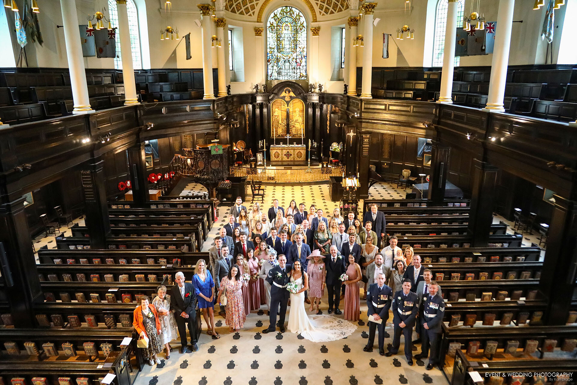 A large wedding day group shot taken from the rear balcony of the St Clements Danes church on a Central London wedding day