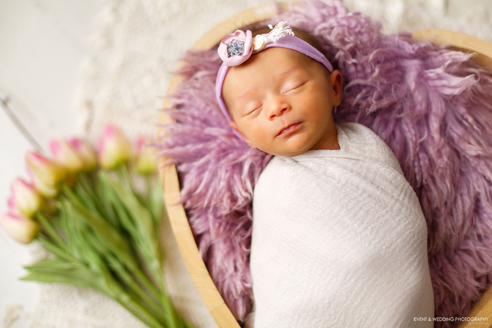 A tiny baby girl asleep in our wooden heart-shaped bowl during her newborn photo shoot