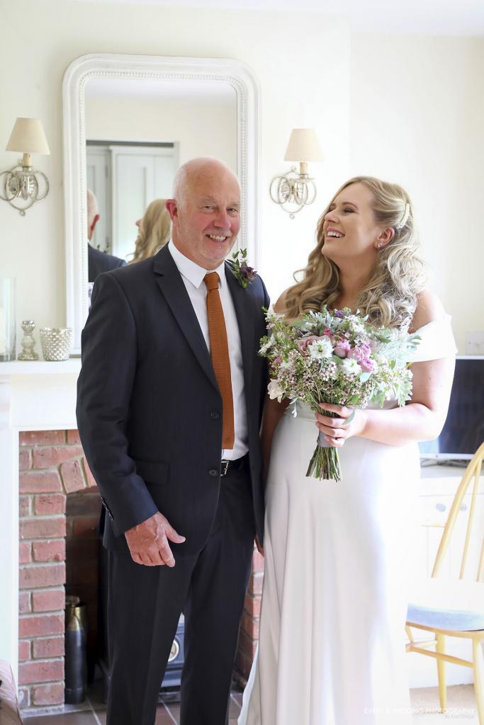 The bride poses with her dad before setting off from the family home for her Kelmarsh Hall wedding