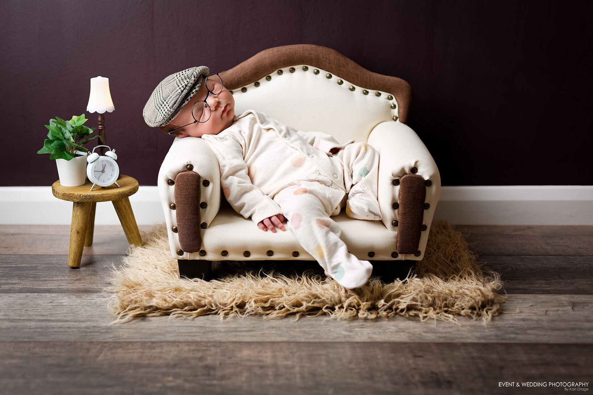 Newborn baby boy asleep in a white upholstered sofa during his newborn photo shoot in a Northampton newborn photo studio