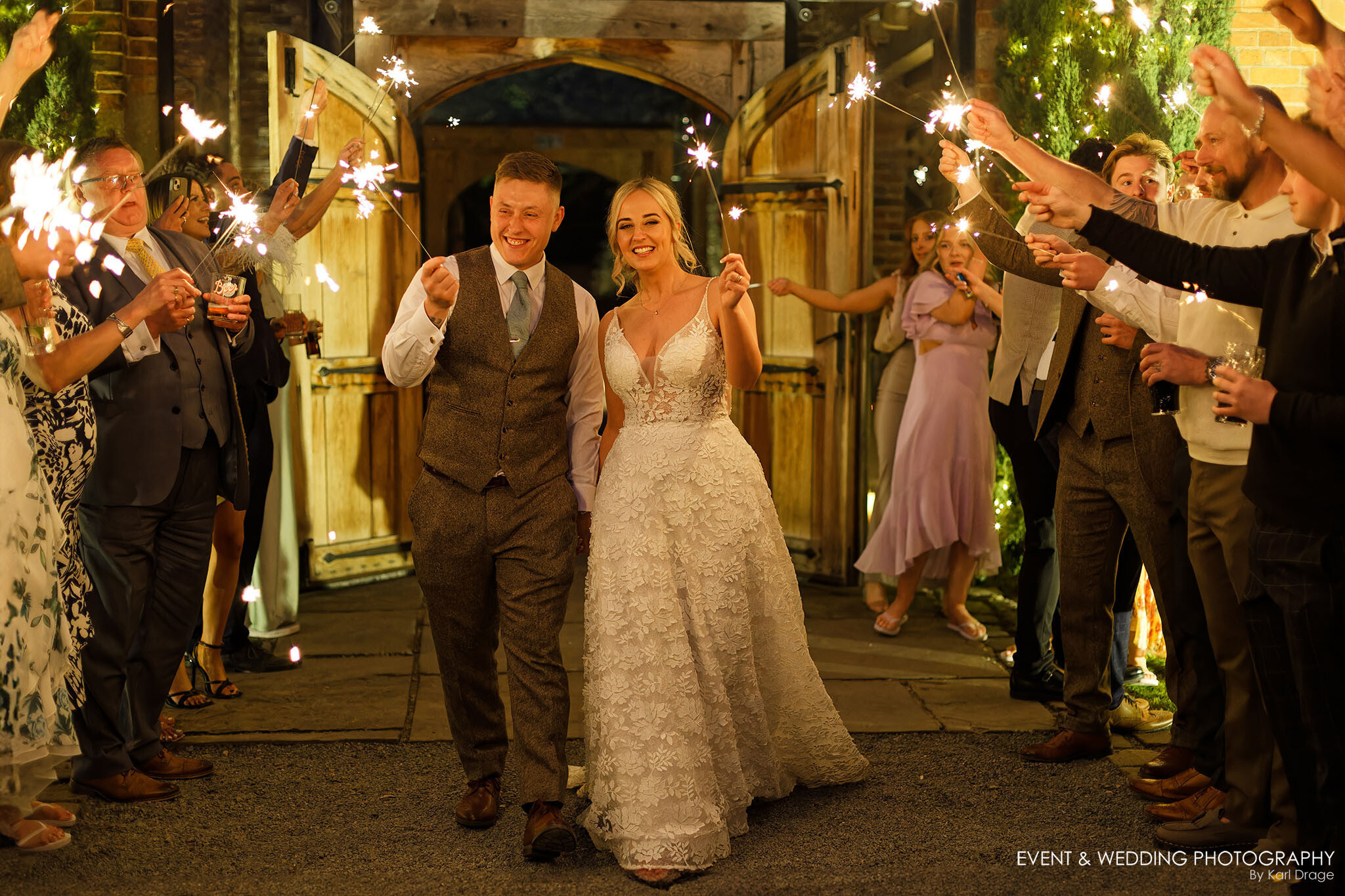 Newlyweds walk through a sparkler guard of honour on their Shustoke Farm Barns wedding day.