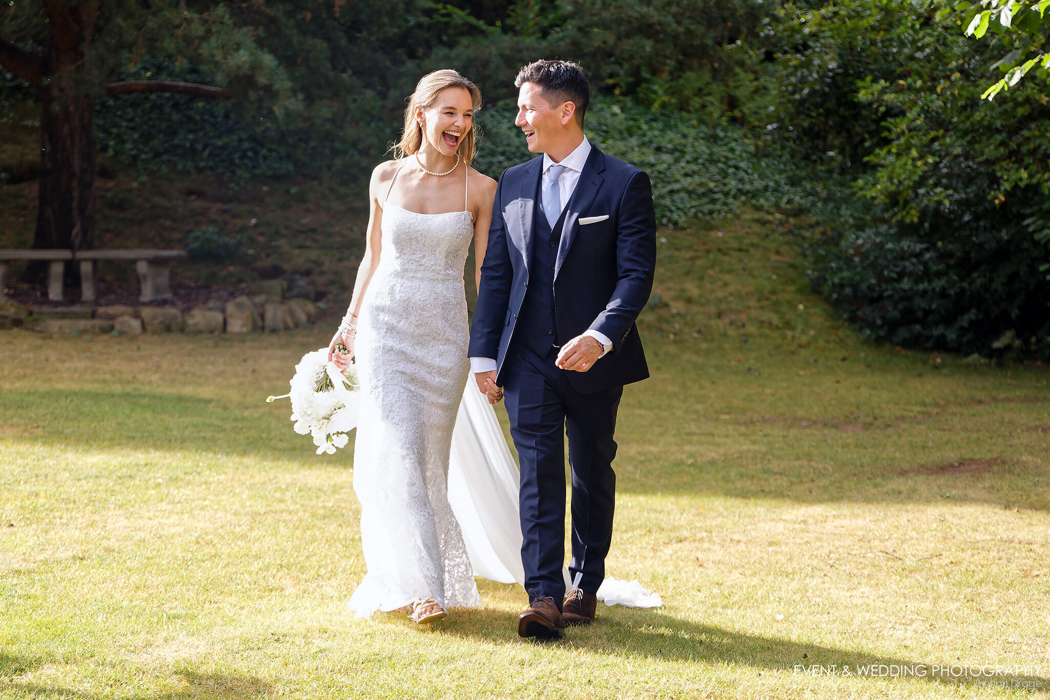 Newlyweds walk hand-in-hand across the Kettering Park Hotel grass on their wedding day.